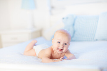 Baby boy on white bed