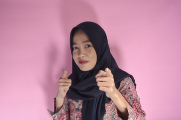 Image of happy young business woman posing isolated above. Wearing batik clothes and hijab