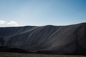 Black volcanic sand surface on the crater rim, close up aerial view. Texture, background, abstract concepts.