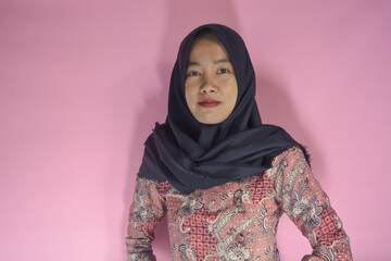 Image of happy young business woman posing isolated above. Wearing batik clothes and hijab