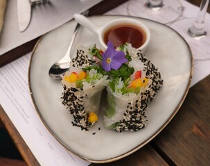 Vietnamese Rice Paper Rolls with sauce and topped with flowers