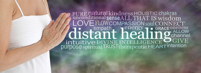 Lightworker sending distant healing - mature female in white dress with hands in prayer position beside a DISTANT HEALING word cloud on a murky energy field background
- 754962593