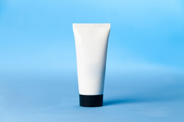 White sunscreen bottle on blue background. Sunscreen concept. Skin care concept. Copy space.