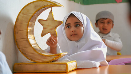 Kindergarten children wearing prayer clothes to celebrate of Ramadan. Ramadan Crescent.