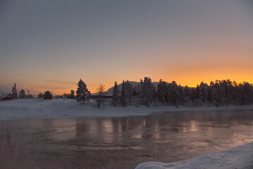Naklejka premium Russia. The South of Western Siberia, the Altai Mountains. A cloudless frosty dawn on the not frozen snow-covered Biya River near the village of Kebezen.