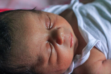 Fototapeta na wymiar Cute newborn baby sleeps with cute expression. Asian newborn baby sleeping. life concept.
