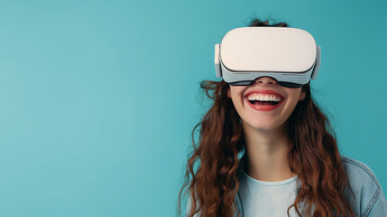 Close-up of young laughing enthusiastic woman wearing white augmented virtual reality glasses on studio blue background with copy space