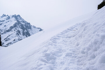 A trail in deep snow high in the mountains not far from Almaty on the route to Mount Kaskabas.
