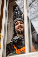 Fototapeta na wymiar Portrait Of Man Cleaning Windows Of Home