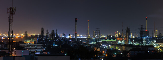 Panorama night cityscape and oil refinery, petroleum oil yard, tank storage field. Nice lighting cover the city. Business and industrail, import and export, international transportation.