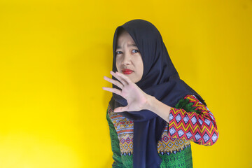 Young Asian woman with scared expression and giving refusing hand gesture.