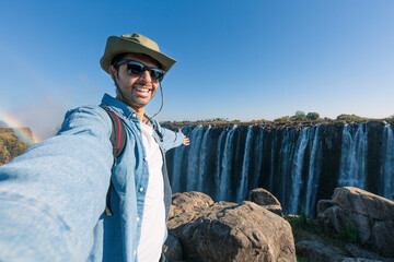 A tourist takes a selfie at Victoria Falls on the Zambezi River, located on the border between Zambia and Zimbabwe, the largest waterfall in the world.