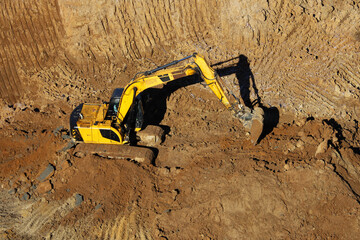 Crawler excavator scoops the earth with a bucket. Earthmoving works, digging in a quarry