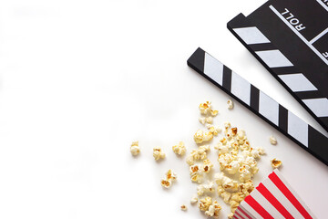 Clapperboard or movie slate black color with popcorn on white background. Cinema industry, video...