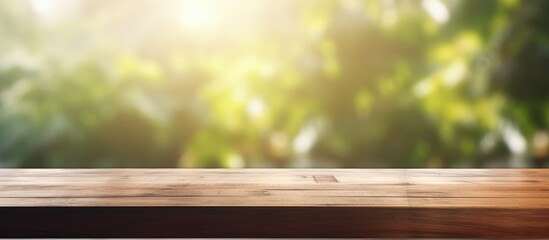 Fototapeta premium A wooden table top is shown with a blurred background, creating a sense of depth and focus on the surface. The background features a window with sunlight streaming in, casting soft shadows.