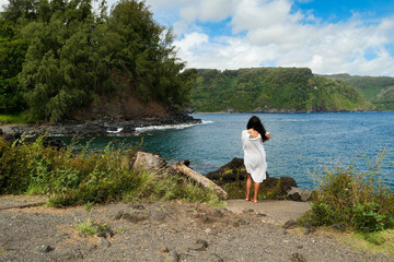 Young Woman Enjoying a Summer Vacation Trip looking at the Sea and Sky