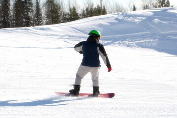 A snowboarder rides a snowboard. Winter recreation.Snowboarding on the mountain.