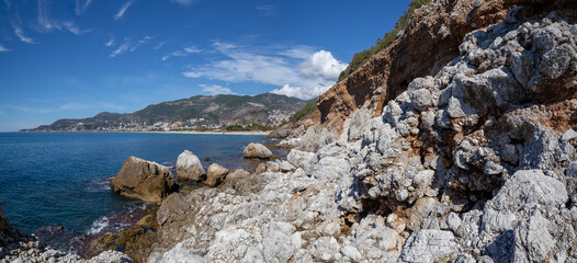 Beautiful panoramic view of the rocky coast and beach of the Mediterranean Sea in the city of Alanya Turkey in good sunny weather in February.