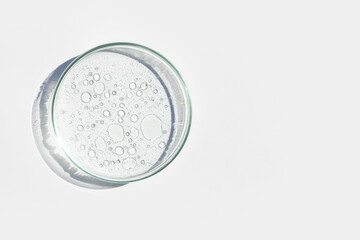 Petri dish. Petri cups with liquid. Kit. Chemical elements, oil, cosmetics. Gel, water, molecules, viruses. Close-up. On a white background.