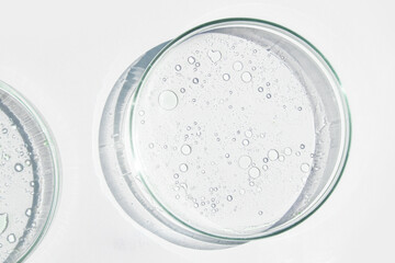 Petri dish. Petri cups with liquid. Kit. Chemical elements, oil, cosmetics. Gel, water, molecules, viruses. Close-up. On a white background.