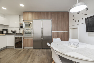 Image of a furnished kitchen in a single-family home with integrated stainless steel appliances...