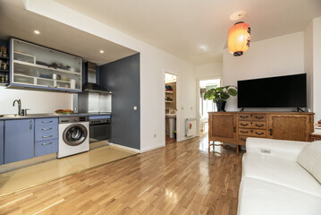 Loft-style apartment with open kitchen with blue furniture, parquet floors and access to other rooms