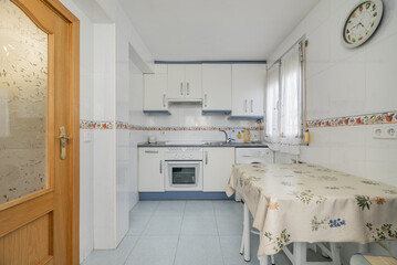kitchen with blue and white furniture, light blue stoneware floors, table with oilcloth tablecloth...