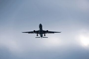 Airplane flying in sky with clouds. Passenger plane at flight, travel concept