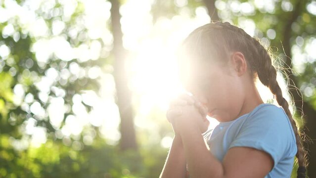 child pray. young gratitude a god religion concept. little girl in nature lifestyle outdoors praying dreams of happiness to god. praise worship freedom concept. kid praying in the forest