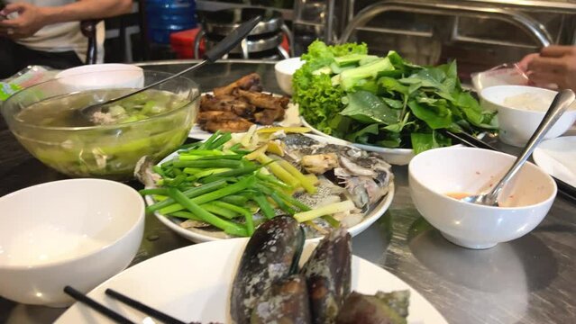 Vietnamese food shells mussels rapan fish cooking Vietnamese soup with green leaves and pieces