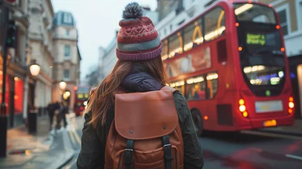 Zelfklevend Fotobehang female tourist backpacker looking at 2 storey or double-decker red bus in  London, England. Wanderlust concept. © Tepsarit