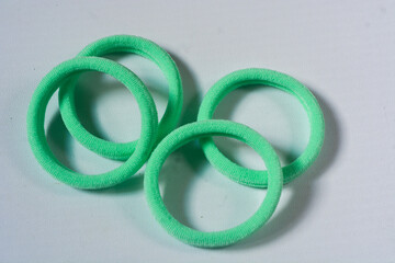 Fototapeta premium A hair scrunchie as a hair tie in a beautiful pastel green color made from satin fabric with a white background, so elegant and fashionable. Great hair tie accessory for girls and women.