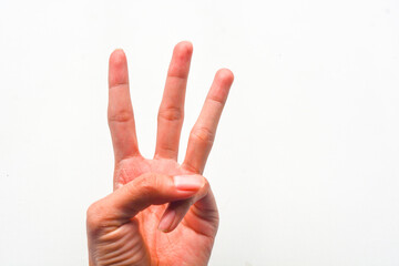 Do the hand, showing the signal symbol number three on the background of p. Signing number 3. Number three in sign language. Third and counting three concepts. 3 fingers up