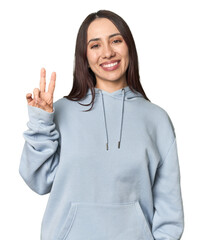 Modern young Caucasian woman portrait on studio background joyful and carefree showing a peace...