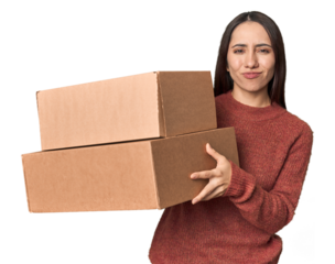 Young Caucasian woman holding moving boxes