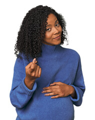 Pregnant African American woman in studio pointing with finger at you as if inviting come closer.