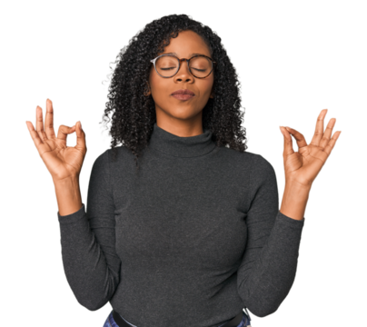 African American woman in studio setting relaxes after hard working day, she is performing yoga.
