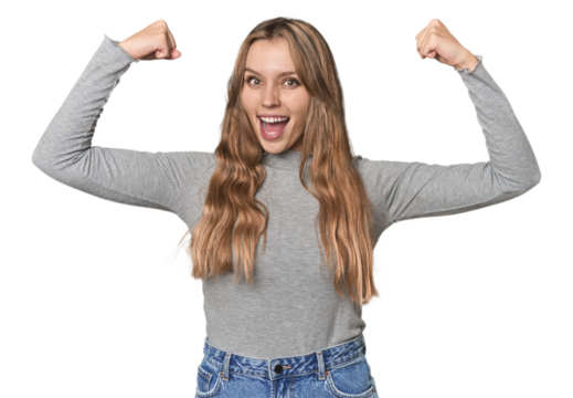 Studio portrait of a blonde Caucasian woman showing strength gesture with arms, symbol of feminine power