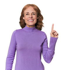 Redhead mid-aged Caucasian woman in studio showing number one with finger.