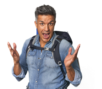 Hispanic hiker with backpack and flask receiving a pleasant surprise, excited and raising hands.