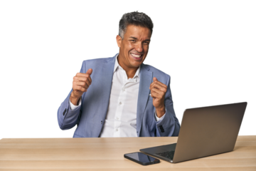 Elegant businessman at desk with laptop dancing and having fun.