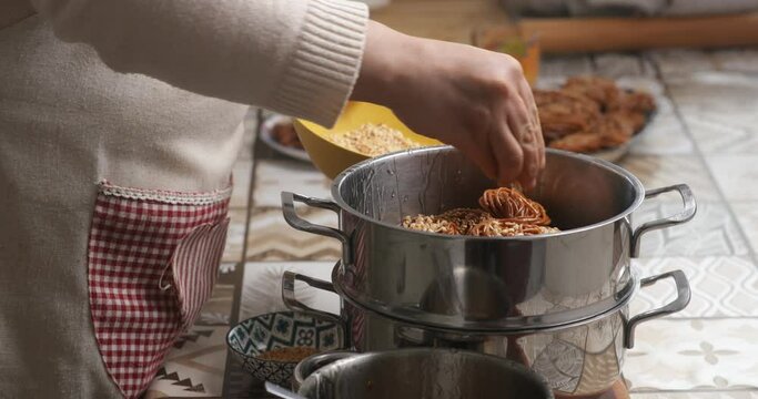 In a gesture of culinary artistry, the homemaker skillfully sprinkles sesame seeds onto chebakia, infusing it with the essence of Moroccan tradition and taste