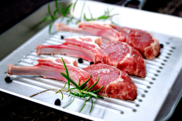 Fresh rack of lamb with spices, on the table, natural color, beautiful photo for a menu in a restaurant. Rosemary. Looks very tasty.