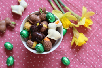 Milk chocolate bunny and eggs on a table. Bright and colorful Easter card. 