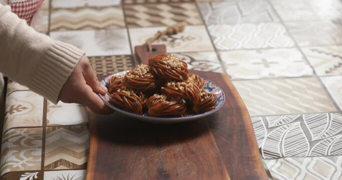 An elegant presentation of chebakia bouchnikha, meticulously arranged on a decorative platter, showcases the intricate beauty and rich flavors of this traditional Moroccan pastry