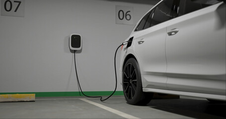 Generic electric crossover car connected to charging box. EV vehicle plugged in energy station, recharge battery at shopping mall or urban city house parking lot.