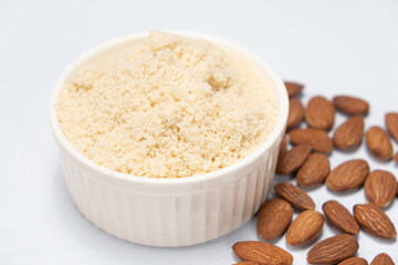 Almond flour and almonds on a white background