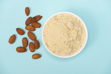 Almond flour and almonds on a blue background top view