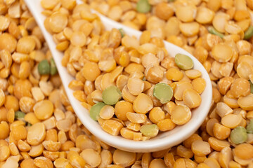 Pea yellow groats grains cereal in spoon close-up macro.