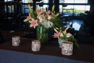 Beautiful bouquet of lilies in vases on the table. Still life floral arrangement 